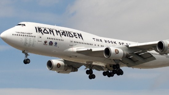 The Iron Maiden tour plane flying with blue sky in the background.